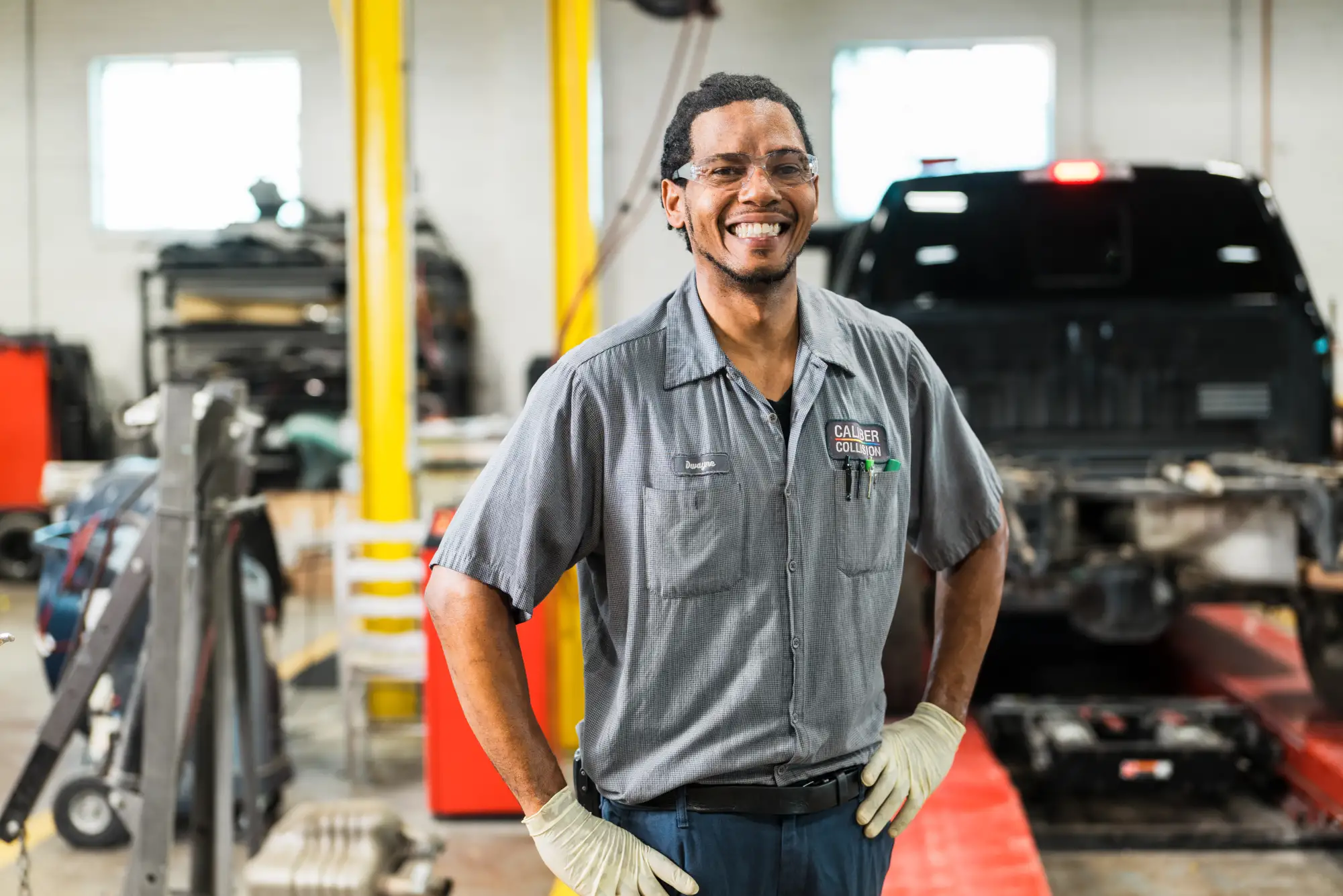 Caliber Collision Body Repair Tech in center garage.